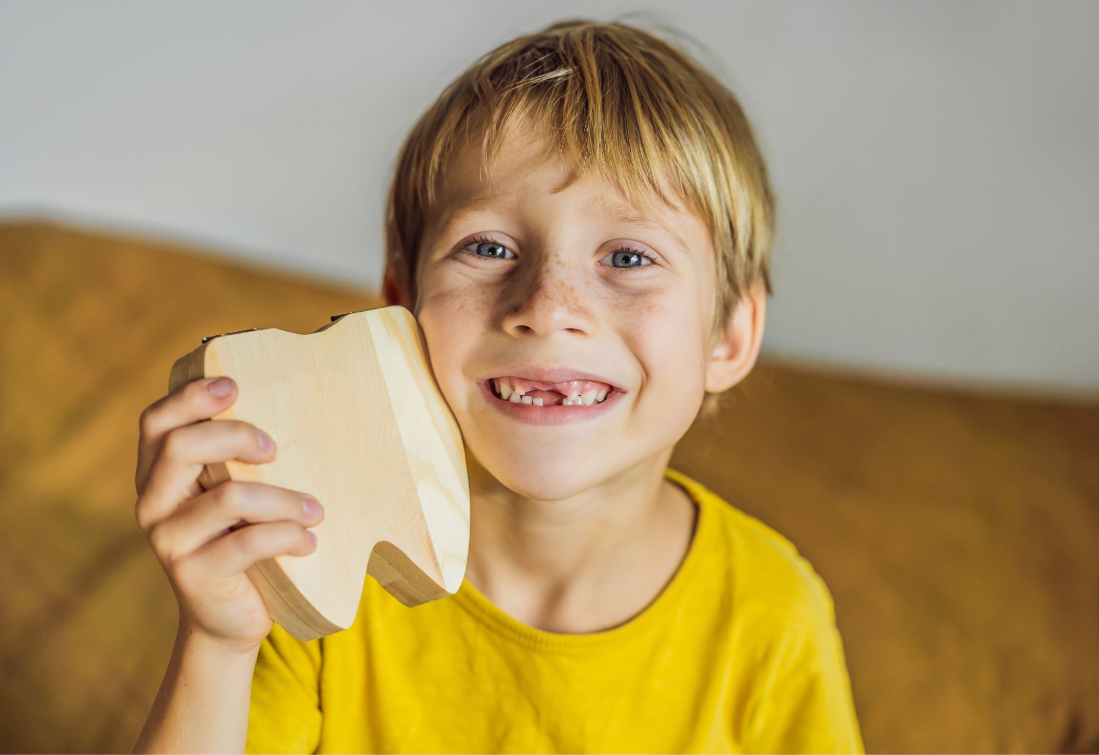 Un bambino sorridente mostra i denti da latte